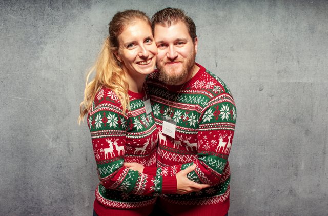 Dasselbe Paar, von der KI in Partner-Weihnachtspullover gesteckt